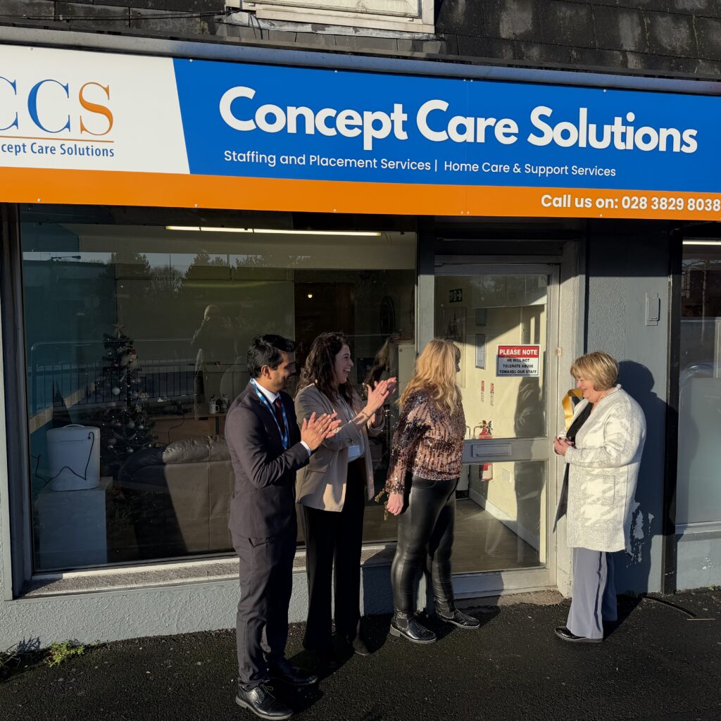 A group of Concept Care Solutions staff celebrating the opening of the new Northern Ireland branch outside the office storefront in Portadown.